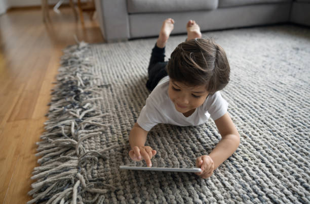 Girl using tab laying on floor | Johnston Paint & Decorating